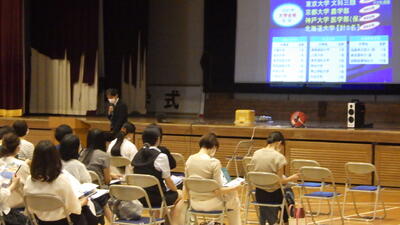 体育館で説明を聞く保護者